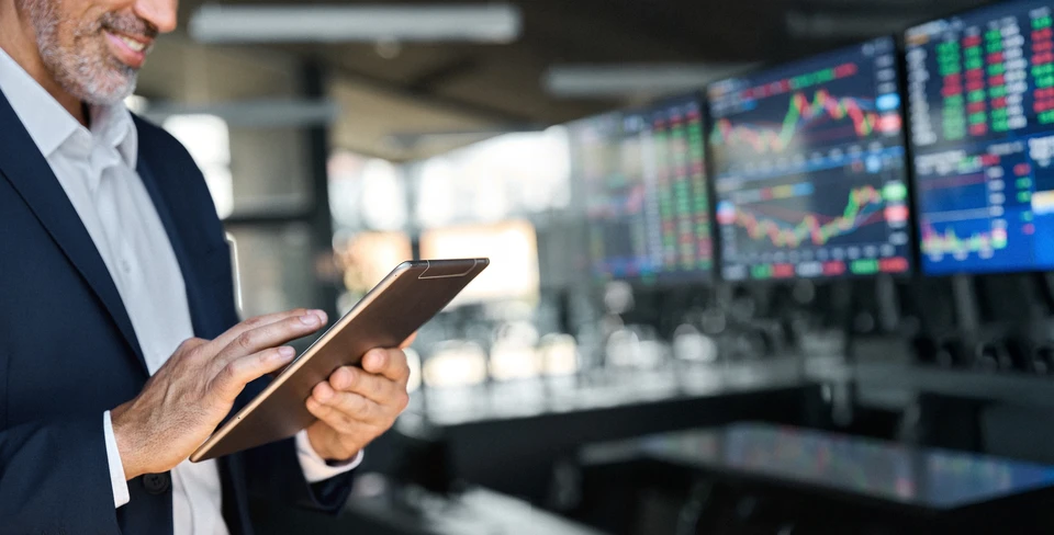 Salle de formation moderne avec participants assis face à des formateurs debout près d'un tableau blanc